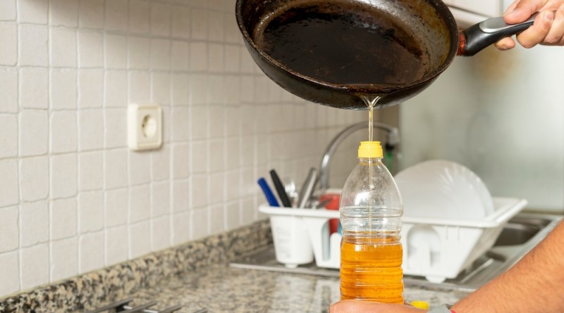 Man,Placing,Recycled,Edible,Oil,From,A,Frying,Pan,Into
