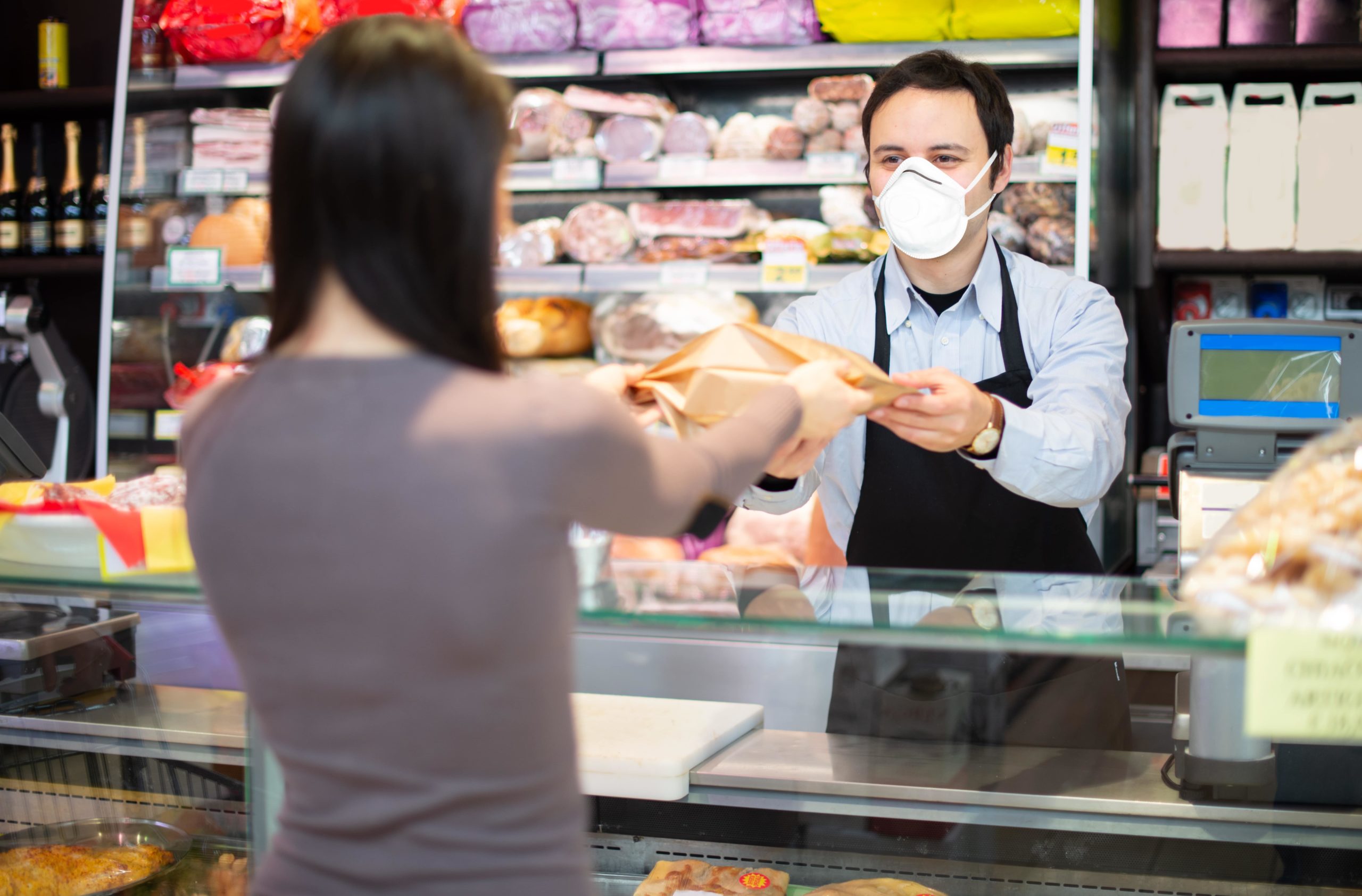 shopkeeper-serving-a-customer-while-wearing-a-mask-min-scaled